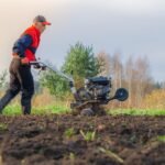 Un homme travaille la terre dans le jardin